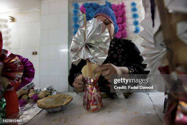 Woman decorates traditional sugar candy in the factory ahead of Mawlid al-Nabi, the birthday of Prophet Mohammad on September 20, 2022 in Cairo,...