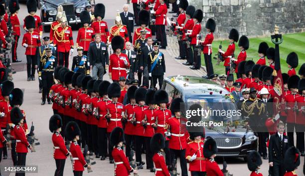 The coffin of Queen Elizabeth II is carried in The state hearse as it proceeds towards St. George's Chapel followed by Prince Edward, Earl of Wessex,...