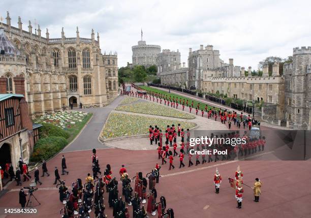 The coffin of Queen Elizabeth II is carried in The state hearse as it proceeds towards St. George's Chapel followed by Prince Edward, Earl of Wessex,...