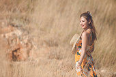 woman in long yellow dress standing in meadow on sunny day,wintage ratro style