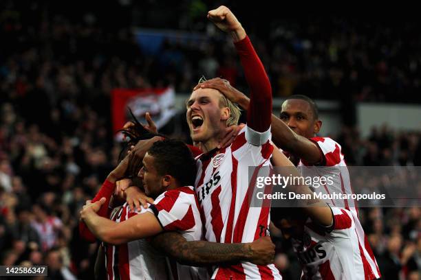 Jeremain Lens of PSV is congratulated by team mates after he scores the third goal of the game with captain Ola Toivonen screaming towards the fans...