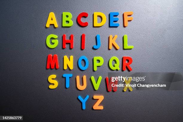 magnetic letters on a fridge door, kids learning with word combination at home concept. - ordre alphabétique photos et images de collection