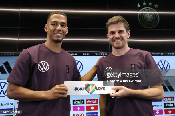 Thilo Kehrer and Jonas Hofmann pose with the team's captain's armband for the FIFA World Cup Qatar 2022 during a Germany press conference at...