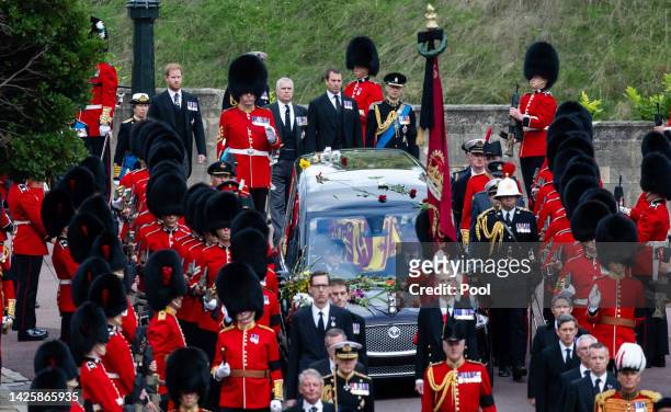 The coffin of Queen Elizabeth II is carried in The state hearse as it proceeds towards St. George's Chapel followed by Prince Edward, Earl of Wessex,...