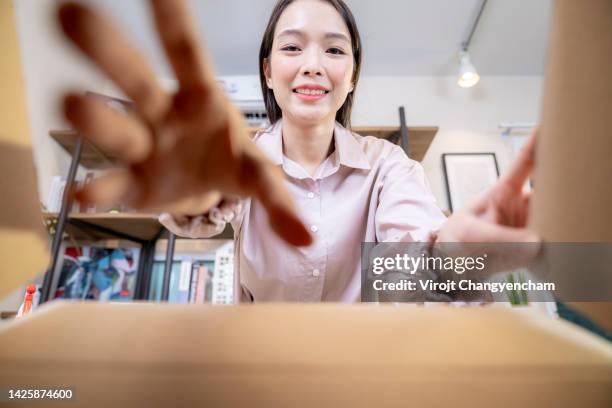 asian woman is unboxing a carton box delivery - send parcel stock pictures, royalty-free photos & images