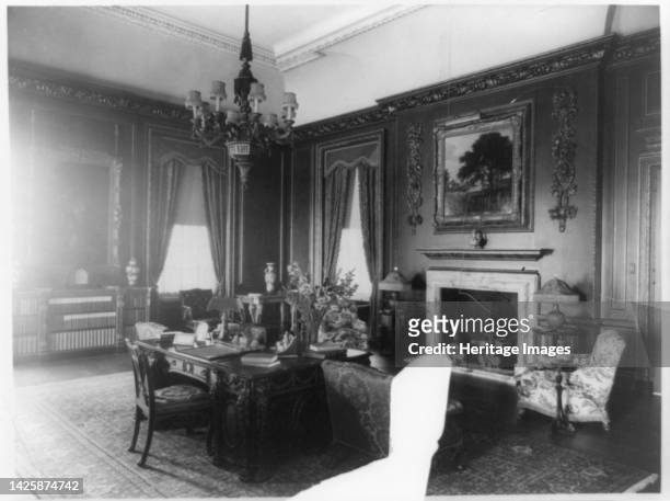 Interior view of Mrs. Hamilton Rice home in Newport, Rhode Island, with desk and fireplace, between 1917 and 1927. The Miramar neoclassical mansion...