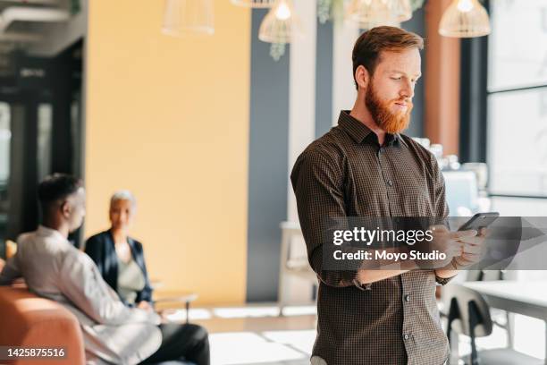 businessman on a phone doing research on an internet website or typing a text message to friends. guy scrolling on social media with a smartphone in a modern corporate office while on a work break - about us stock pictures, royalty-free photos & images