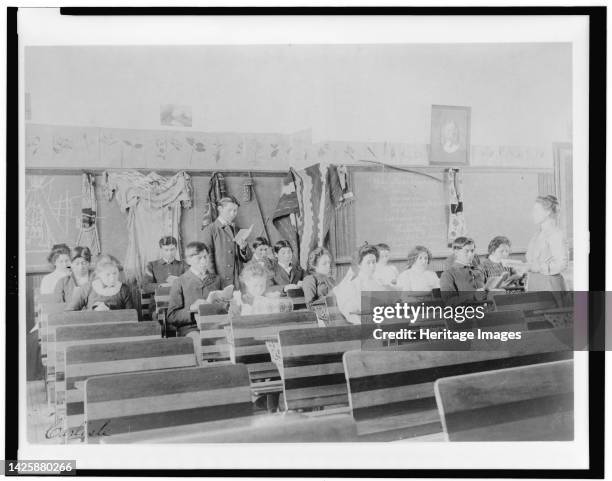 Carlisle, between 1901 and 1903. Classroom at the Indian Industrial School, Carlisle, Pennsylvania, showing teacher observing students reading. ....