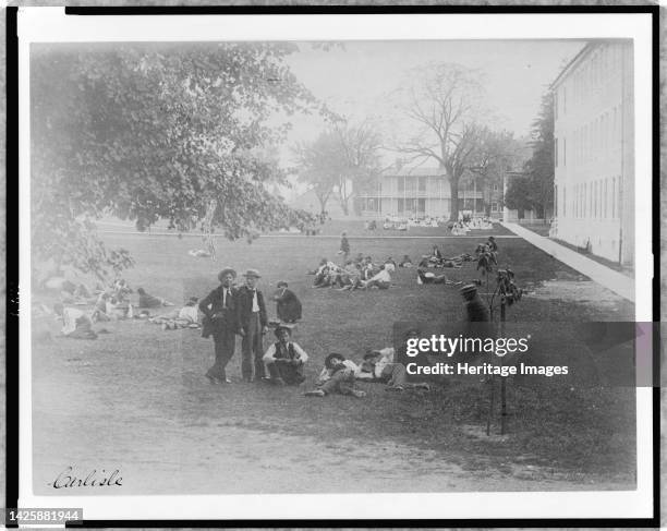 Carlisle, between 1901 and 1903. Students relaxing on lawn at United States Indian School, Carlisle, Pennsylvania. . Artist Frances Benjamin Johnston.