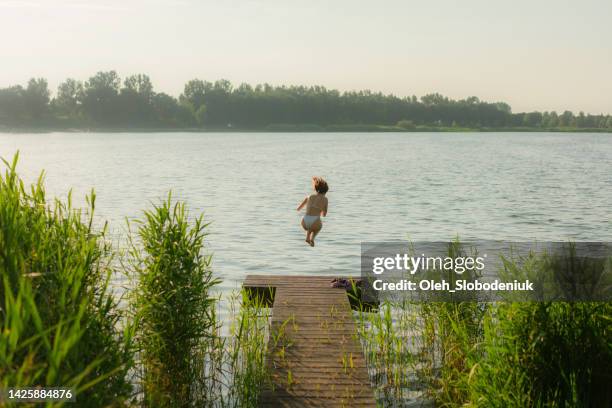 woman running and diving into the lake - avkopplingsaktivitet bildbanksfoton och bilder