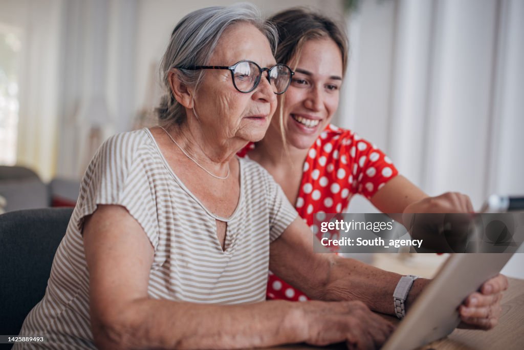 Großmutter und Enkelin benutzen Tablet