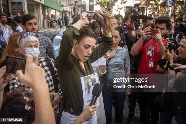 Woman cuts her hair during a protest over the death of Iranian Mahsa Amini outside the Iranian Consulate on September 21, 2022 in Istanbul,Turkey....