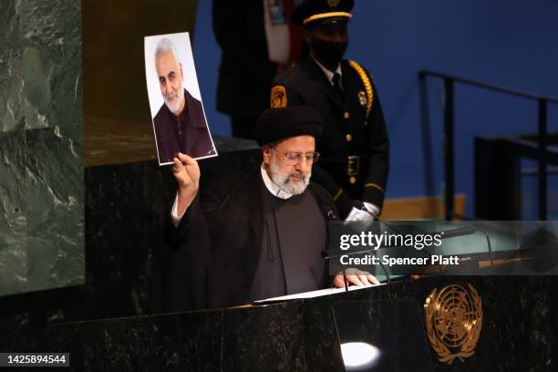 Iranian President Ebrahim Raisi holds a picture of Qasem Soleimani, an Iranian major general who was killed by a U.S. Drone strike, as he speaks at...