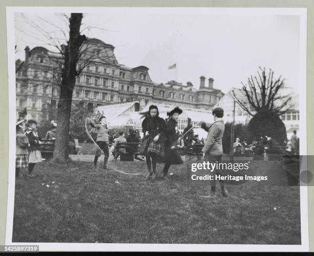 Children jumping rope on the White House lawn during annual Easter egg roll with State, War, and Navy Building in background printed 1964. Artist...