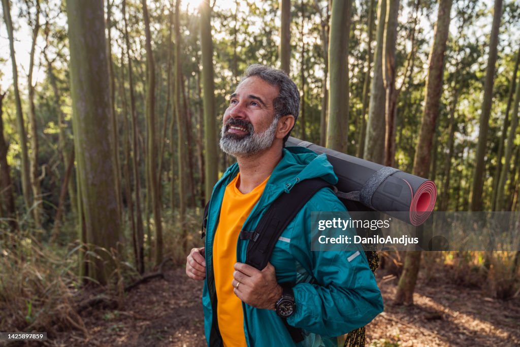 Senior man walking through the woods-hiking