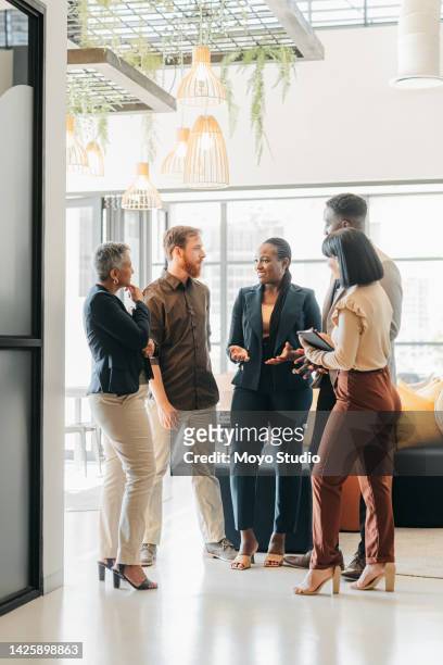 corporate team and leader talking in the company lounge about creative collaboration project. diversity, staff and professional people planning meeting in office. work friends having a conversation. - multiracial group stock pictures, royalty-free photos & images