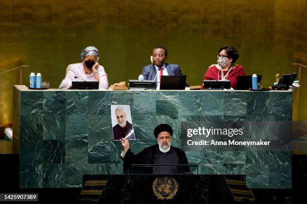 Iranian President Ebrahim Raisi holds a picture of Qasem Soleimani, an Iranian major general who was killed by a U.S. Drone strike, as he speaks at...