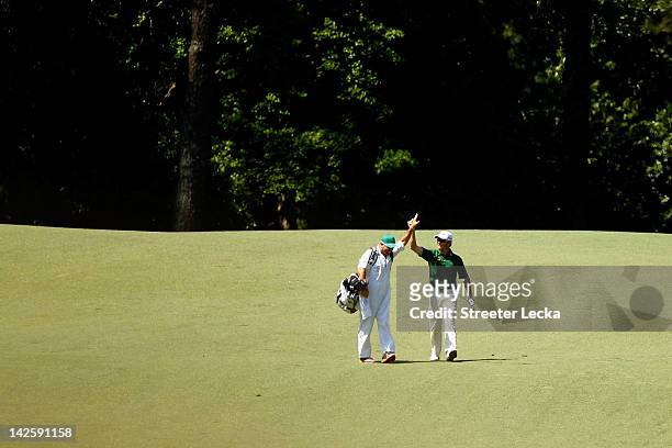Louis Oosthuizen of South Africa celebrates with his caddie Wynand Stander after making an albatross on the second hole during the final round of the...