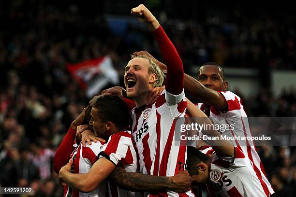 Jeremain Lens of PSV is congratulated by team mates after he scores the third goal of the game with captain Ola Toivonen screaming towards the fans...