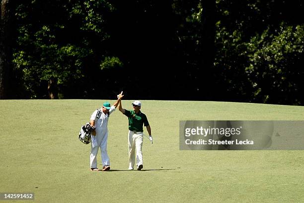 Louis Oosthuizen of South Africa celebrates with his caddie Wynand Stander after making an albatross on the second hole during the final round of the...