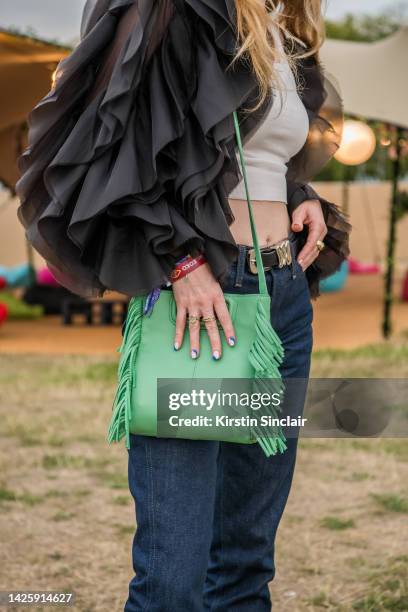 Fiona Jane wears Frame denim jeans and belt, Reformation vest top, Coppenhagen Muse jacket and a Maje bag at Victoria Park on August 26, 2022 in...