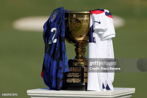 The Presidents Cup trophy is seen alongside U.S. National soccer team jerseys prior to the 2022 Presidents Cup at Quail Hollow Country Club on...