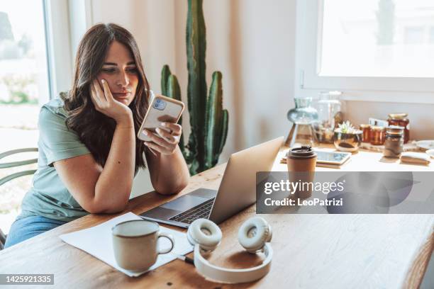 mulher entediada mandando sms no celular durante uma pausa do estudo - bad student - fotografias e filmes do acervo