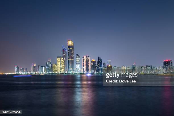 abu dhabi city skyline - united arab emirates night stock pictures, royalty-free photos & images