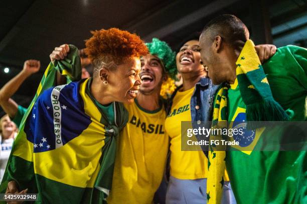 brazilian sports fans watching match and celebrating at a bar - a brazil supporter stockfoto's en -beelden