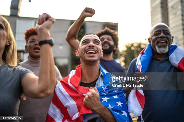 american sports team fans watching a match and celebrating outdoors - basketball match on tv stockfoto's en -beelden