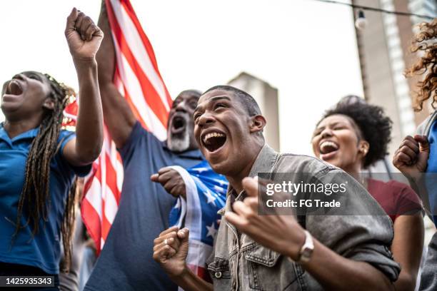 american sports team fans watching a match and celebrating outdoors - basketball match on tv stockfoto's en -beelden