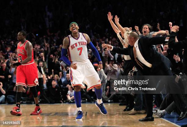 Carmelo Anthony of the New York Knicks celebrates his game winning three pointer against as Luol Deng of the Chicago Bulls looks on at Madison Square...