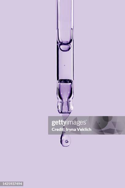 close-up pipette with face serum or essential oil with oxygen aqua bubbles in trendy color of the year 2022 very peri purple violet  color background. - oxygen stock-fotos und bilder