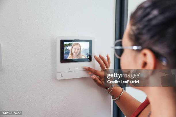 amigos en la puerta, mujer recogiendo videoportero - intercom home fotografías e imágenes de stock