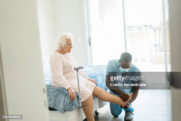 senior woman getting physical therapy treatment at home - varicose vein stock pictures, royalty-free photos & images