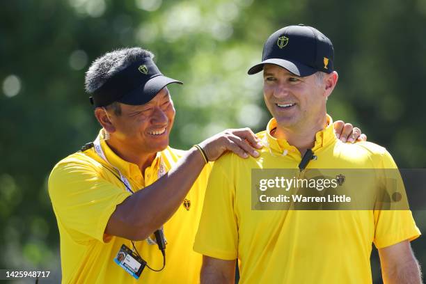 Assistant Captain K.J. Choi and Captain Trevor Immelman of the International Team talk during a practice round prior to the 2022 Presidents Cup at...