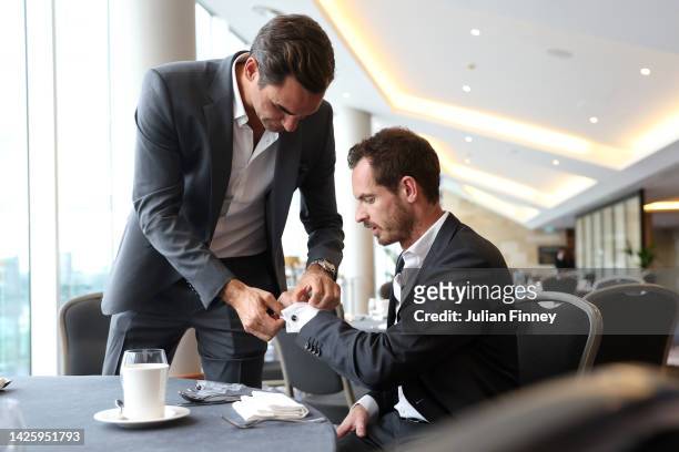 Roger Federer of Team Europe helps teammate Andy Murray with his cufflinks as the players prepare for a photoshoot on September 21, 2022 in London,...