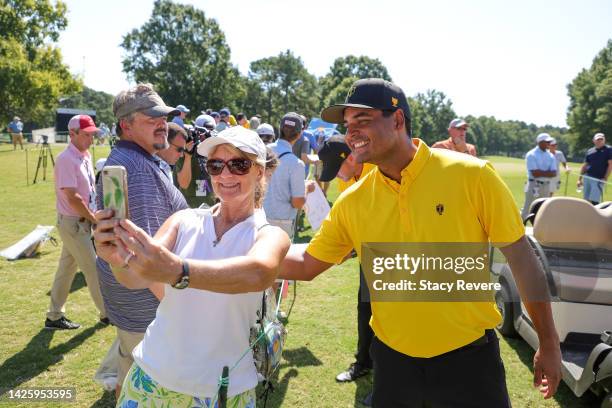Sebastian Munoz of Colombia the International Team smiles for a photo with a fan during a practice round prior to the 2022 Presidents Cup at Quail...