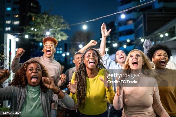 sportfreunde fans schauen sich das spiel an und feiern in einer bar auf dem dach - female fans brazil stock-fotos und bilder
