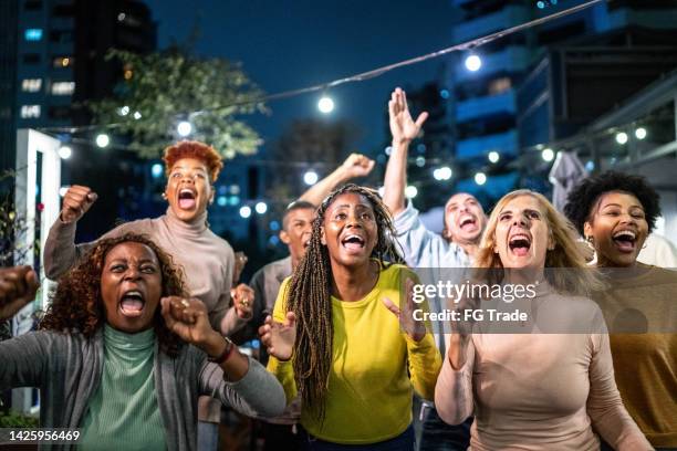 fans d’amis sportifs regardant le match et célébrant dans un bar sur le toit - football américain femme photos et images de collection