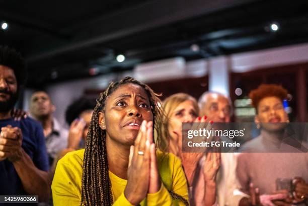 sportfans, die sich ein spiel in einer bar ansehen - women prayer stock-fotos und bilder