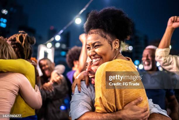 fãs de esportes assistindo a uma partida e celebrando em um telhado de bar - festa - fotografias e filmes do acervo