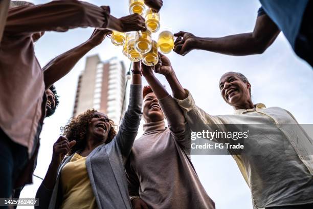 friends doing a celebratory toast with beer during happy hour - beer cheers stock pictures, royalty-free photos & images