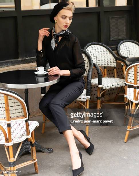 paris, france - portrait of a young woman sitting at the terrace of a parisian cafe - jean marc payet stock-fotos und bilder
