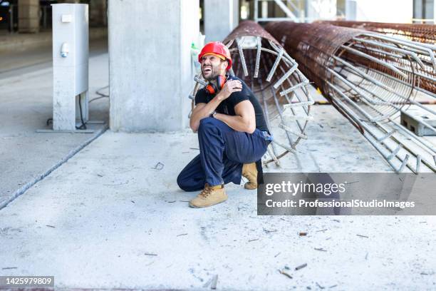 a young construction site worker has an accident at work. - workers compensation stock pictures, royalty-free photos & images