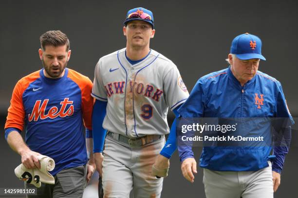 Brandon Nimmo of the New York Mets walks off the field with manager Buck Showalter after being injuried on a play in the first inning against the...