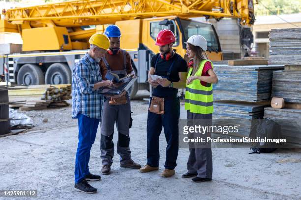 a multicultural group of building workers are making new projects on laptop. - workers compensation stock pictures, royalty-free photos & images