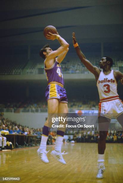 Jerry West of the Los Angeles Lakers shoots over Fred Carter of the Baltimore Bullets during an NBA basketball game circa 1970 at the Baltimore Civic...