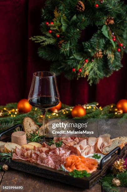 christmas charcuterie board appetizer plate with salami, ham, salmon and red wine for christmas in dark rustic kitchen - charcuterie board 個照片及圖片檔