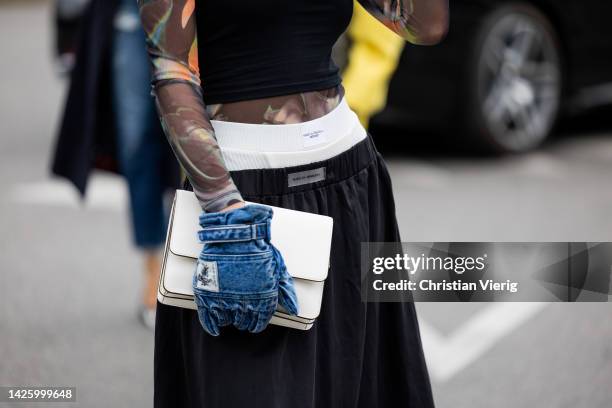 Guest wears denim gloves, boxer shorts, black bag outside Diesel during the Milan Fashion Week - Womenswear Spring/Summer 2023 on September 21, 2022...